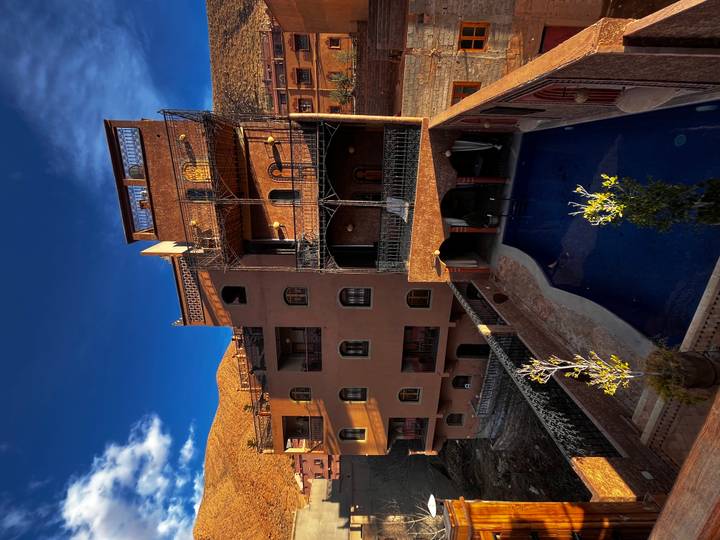 Traditional Moroccan building with intricate architectural details and a pool in the courtyard.