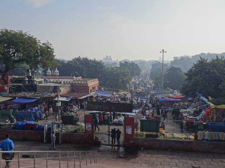 Busy morning market scene with hundreds of stalls, tarps and crowds stretching into the distance.