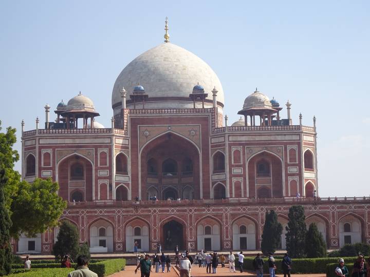 Symmetrical view of red sandstone Humayun's Tomb with blue sky background.