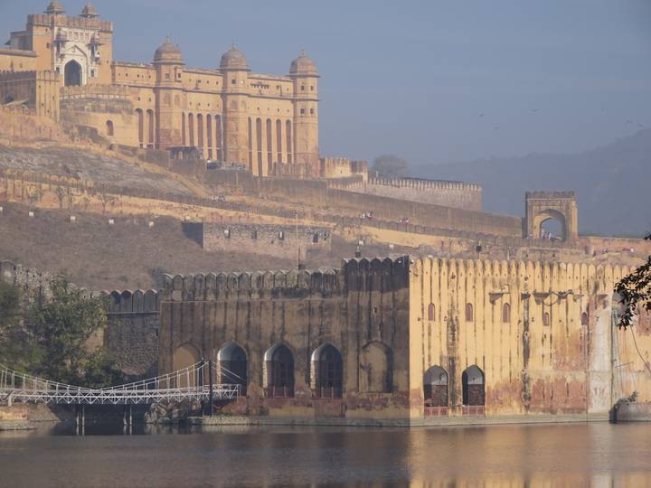 Long defensive walls and arched gateways of Amber Fort stretching across the hillside.