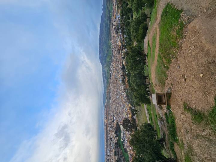 Landscape of Fes medina nestled in a broad valley beneath rolling hills.