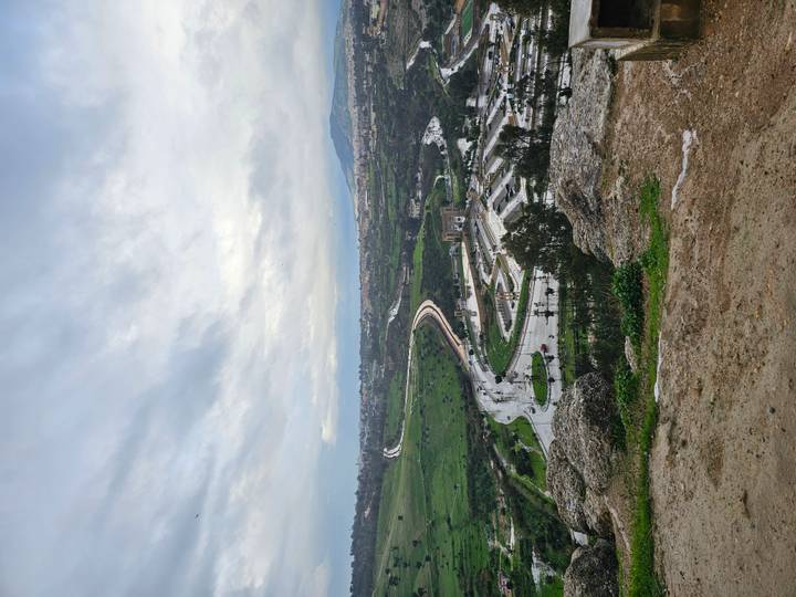 Curving roadway and parklands viewed from a rocky overlook on a gray day near Fes.
