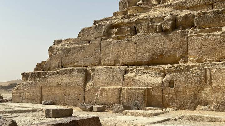 Close-up of massive weathered limestone blocks forming the base of an ancient pyramid.
