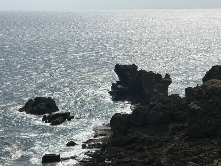 Sun-speckled ocean crashes against jagged volcanic rocks at Taiwan's southern coast.