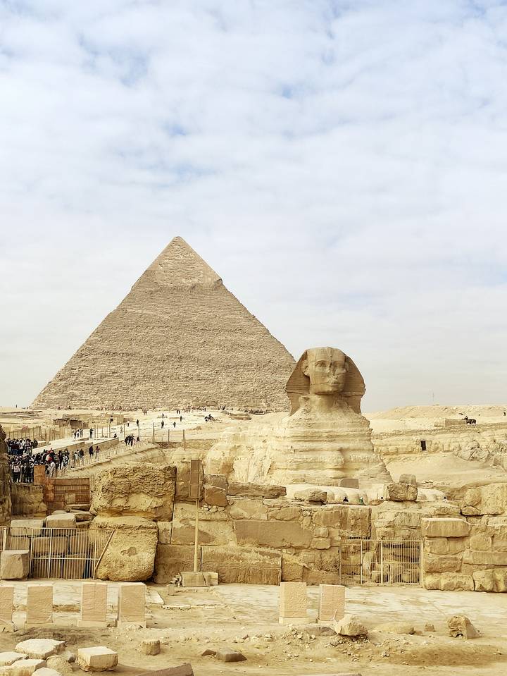 Classic view of the Sphinx before the Pyramid of Khafre with crowds at the Giza Plateau.