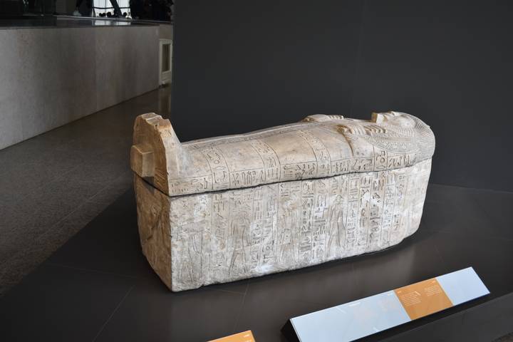 Ancient Egyptian stone sarcophagus displayed on a museum plinth.