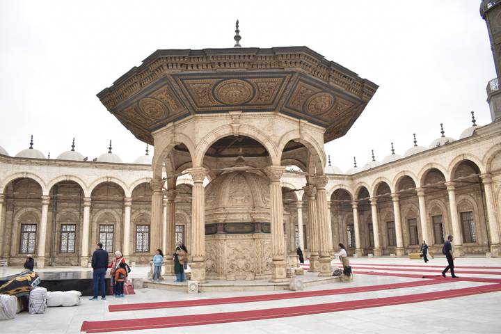Ornate ablution fountain and arched colonnade inside the courtyard of Muhammad Ali Mosque.
