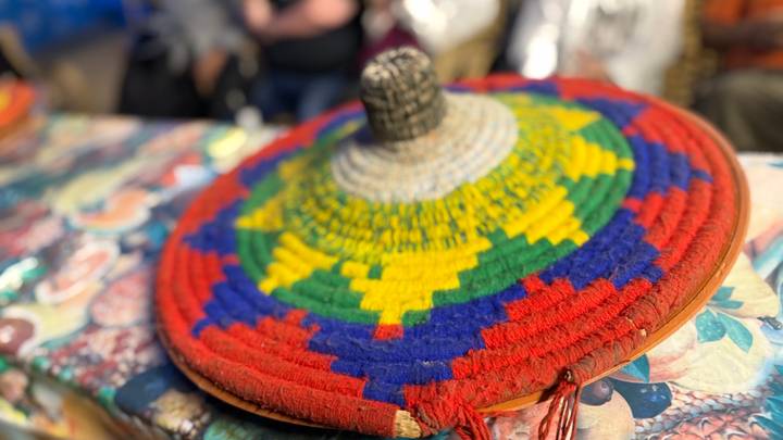 Colorful woven Ethiopian basket lid displayed on a market table