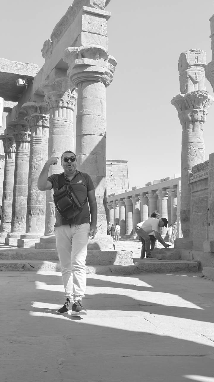 Tour guide energetically explains among towering ancient columns inside a temple