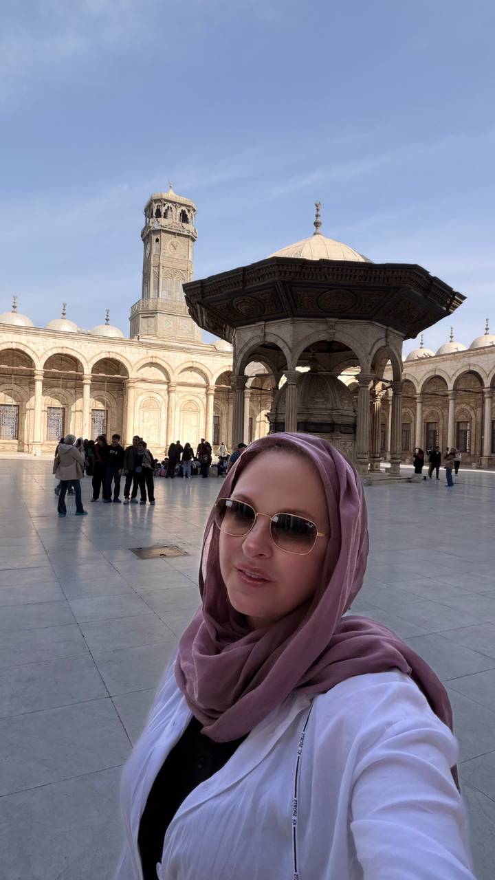 Woman in headscarf takes a selfie in the marble courtyard of the Cairo Citadel mosque