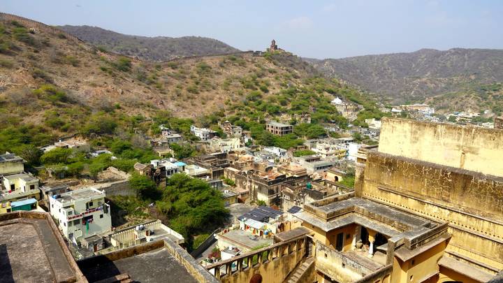Panoramic hill-top view of a desert town framed by arid hills and ancient fort walls