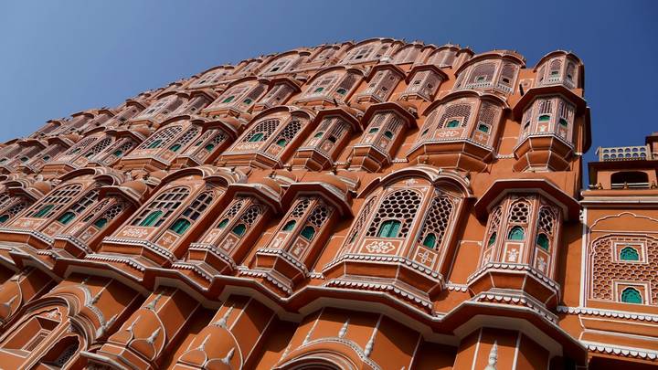 Up-angle view of the vibrant façade of the Hawa Mahal with deep blue sky behind