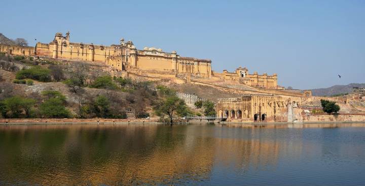Amber Fort sprawling over a rugged hill with its reflection in the still waters below