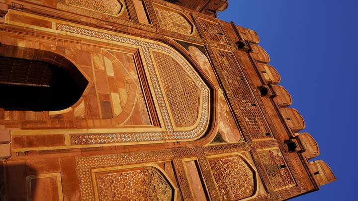 Tall decorated sandstone gateway of Fatehpur Sikri captured against a clear evening sky.
