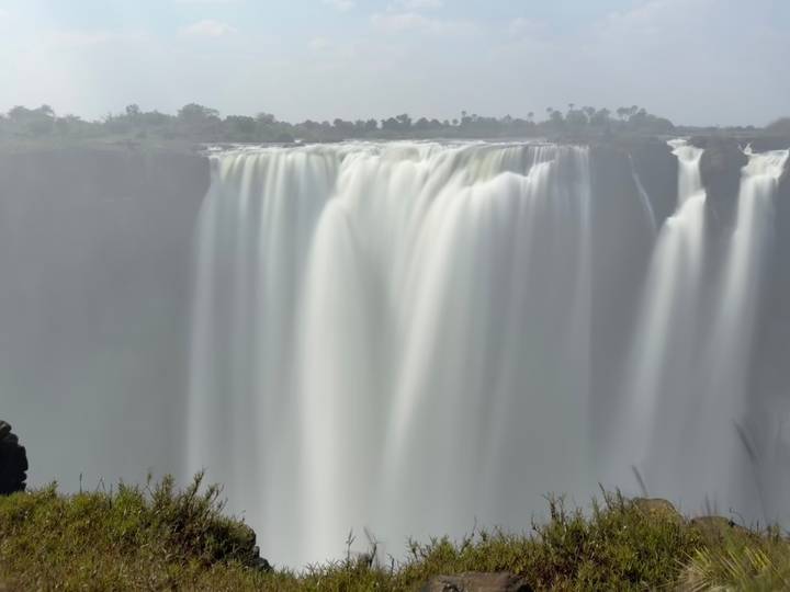 Powerful curtain of Victoria Falls captured with silky long exposure and mist rising.