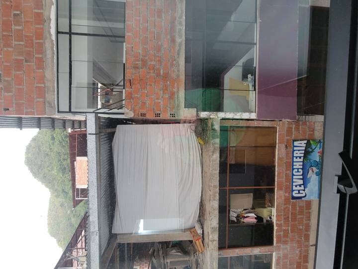 Urban view from window showing brick buildings and a cevicheria sign