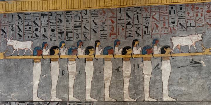Colorful wall reliefs and hieroglyphics inside an ancient Egyptian tomb.