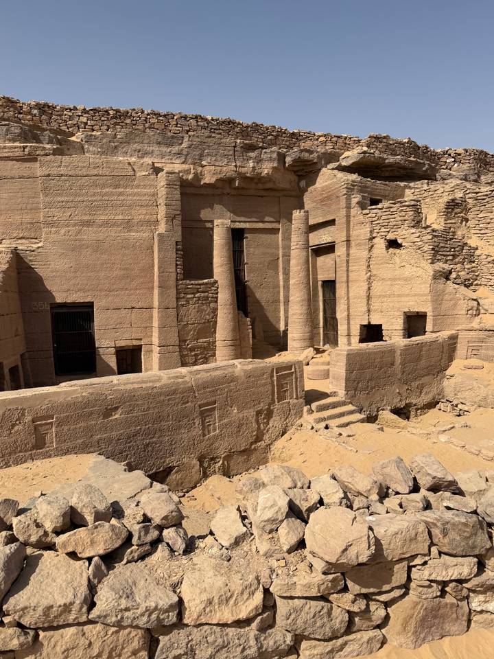 Weathered stone columns and walls of an ancient archaeological dig site.