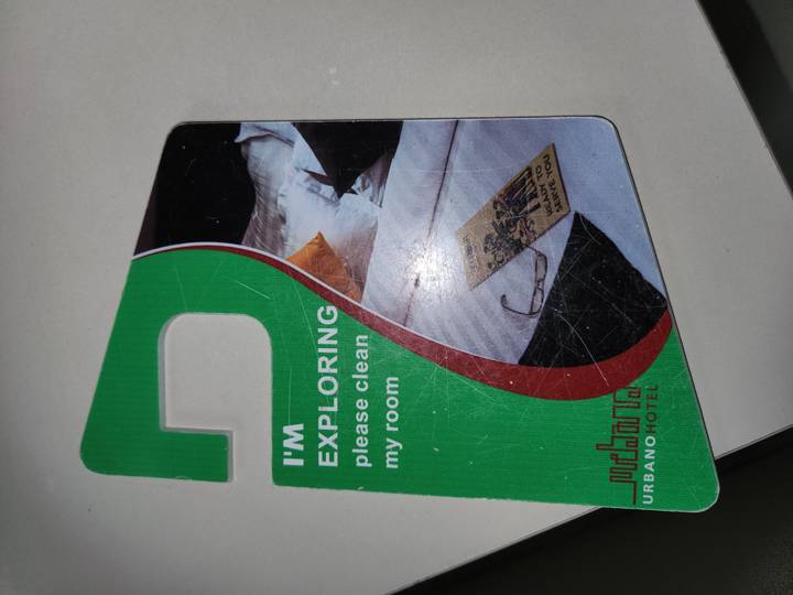 Hotel door hanger card reading "I’m exploring please clean my room" on tabletop.