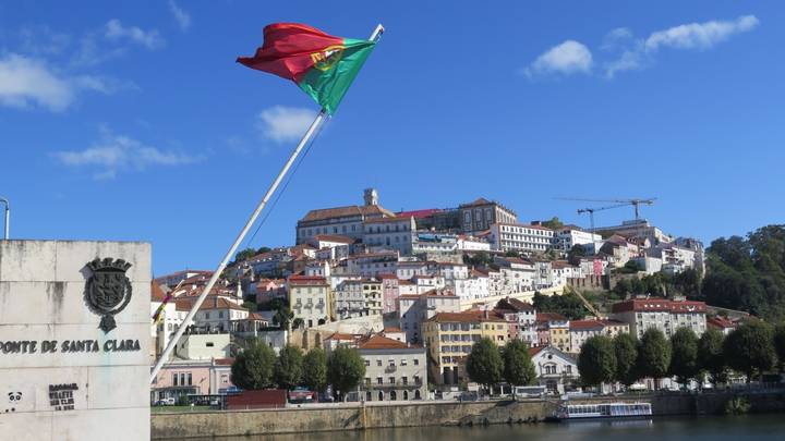 Panoramic view of Coimbra with the Portuguese flag.