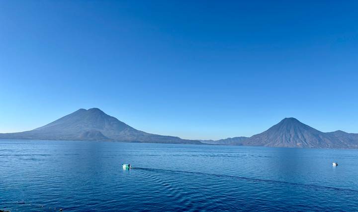 Crystal clear view of twin volcanoes rising above the calm blue waters of Lake Atitlán