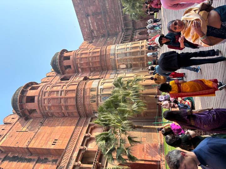 Crowds explore towering red sandstone walls and balconies of Agra Fort