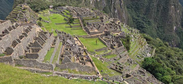 Wide panoramic shot of Machu Picchu citadel nestled on a green ridge