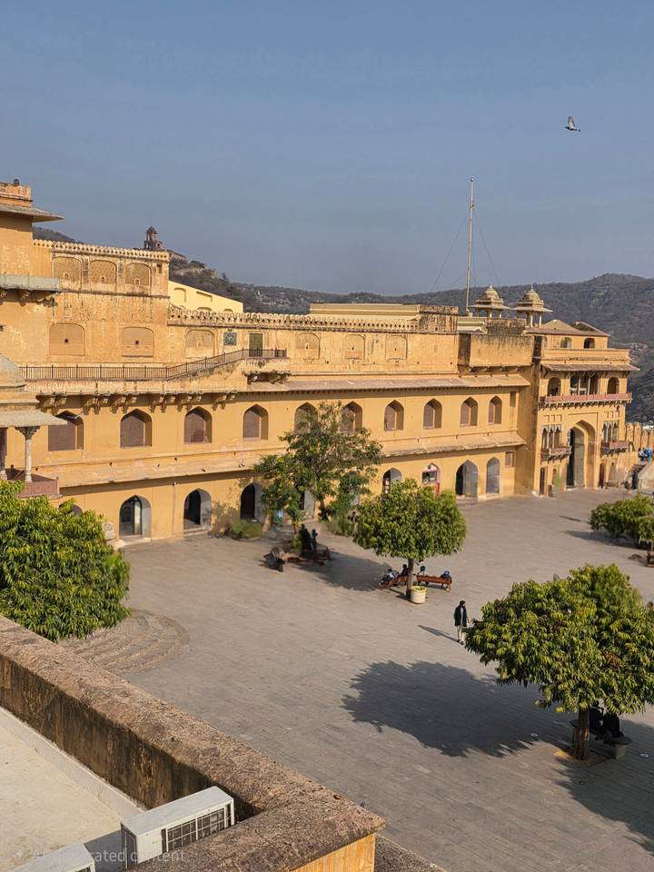 Courtyard and ramparts of Amber Fort in Jaipur viewed from above on sunny afternoon.