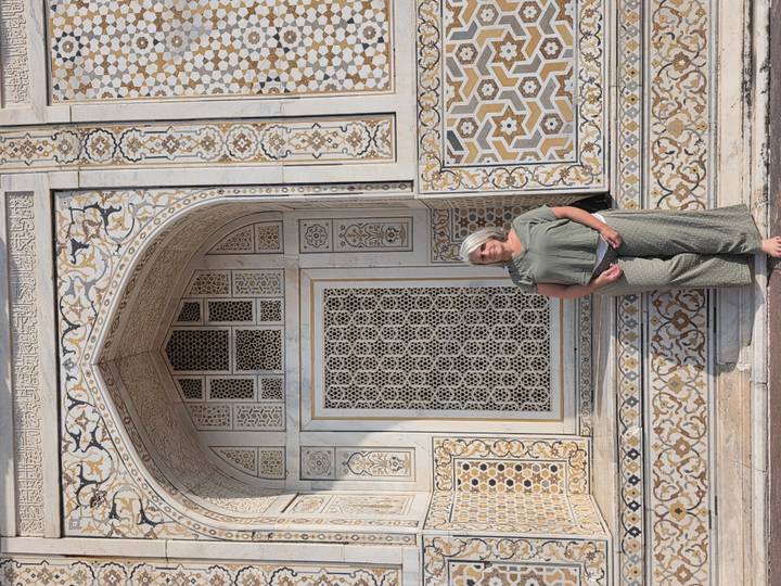 Woman posing beside ornate marble inlay wall at Itimad-ud-Daulah in Agra.