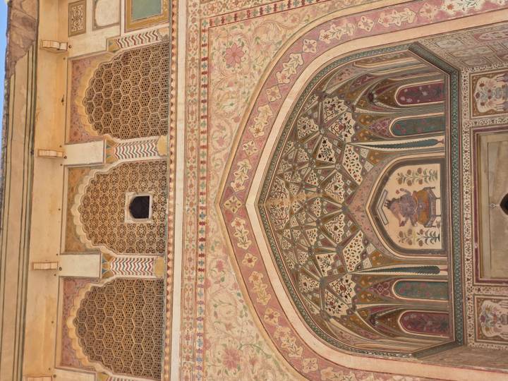 Close-up of an intricately painted and carved Mughal archway with floral motifs.