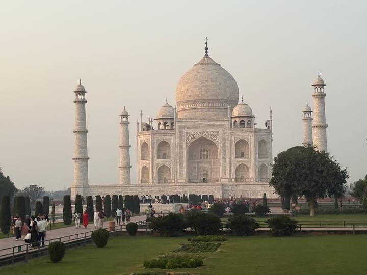 Closer evening view of the marble Taj Mahal framed by gardens and visitors.