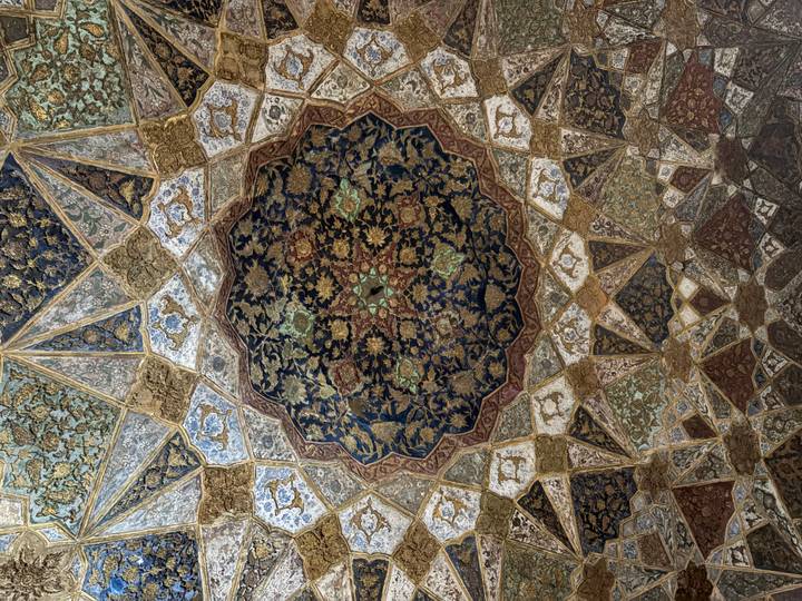 Intricate floral and geometric ceiling artwork with rich blues and golds.