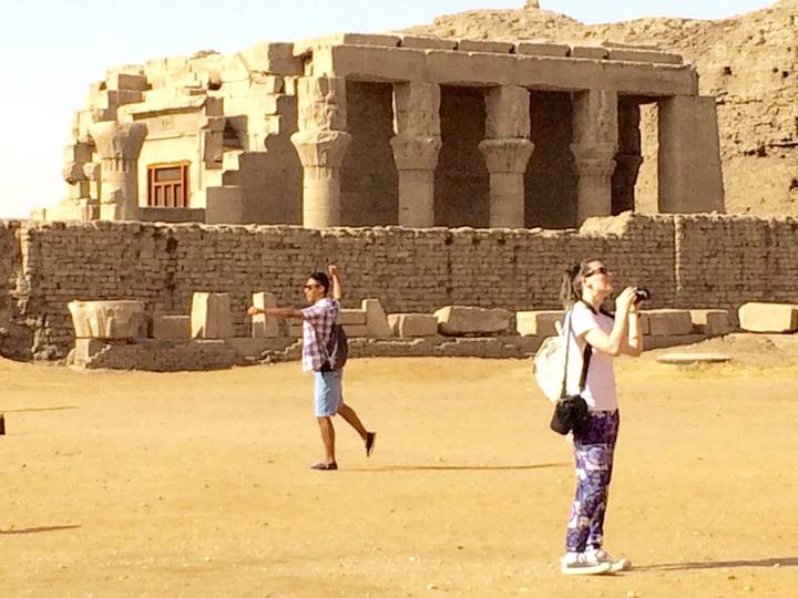 Tourists take selfies and photos outside the sandstone columns of Kom Ombo Temple in Egypt