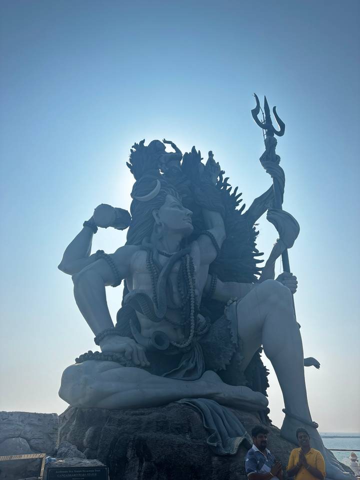 Dramatic back-lit statue of Lord Shiva with sun halo highlighting intricate sculpture details