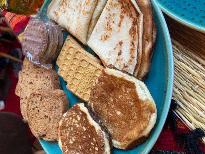 Close-up of a platter with Moroccan pancakes, flatbreads and assorted biscuits.