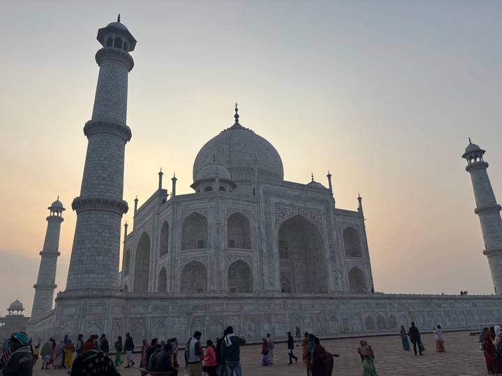 Side view of the Taj Mahal silhouetted against a warm sunset sky.