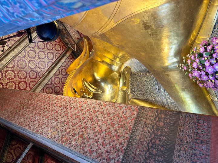 Close-angle interior view of the golden Reclining Buddha statue at Wat Pho.