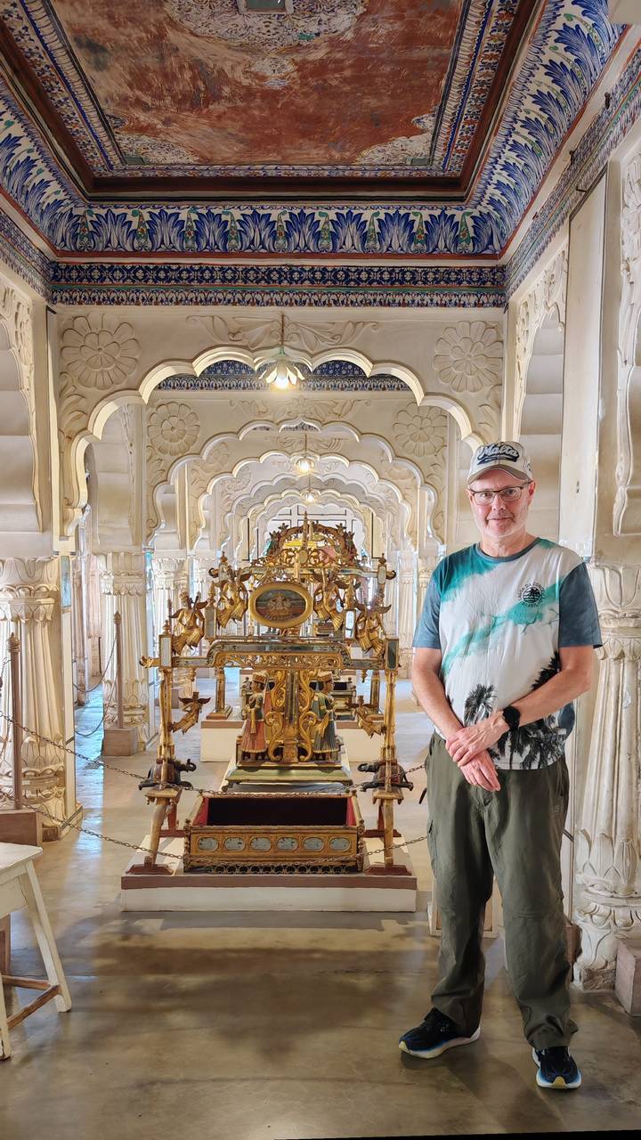 Visitor stands in an ornate marble hall with intricate arches and golden relics.