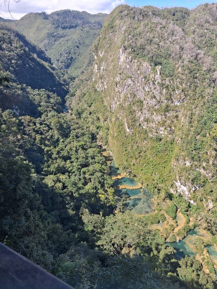 Aerial view of turquoise stepped pools deep in the Semuc Champey jungle canyon.