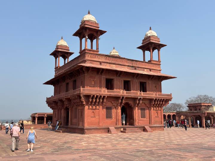 Red sandstone Diwan-i-Khas pavilion at Fatehpur Sikri against a clear blue sky