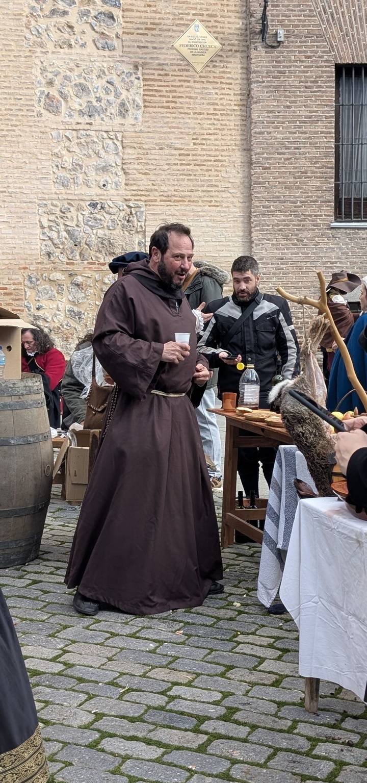 Costumed participants at a medieval-themed market enjoy food and drinks.