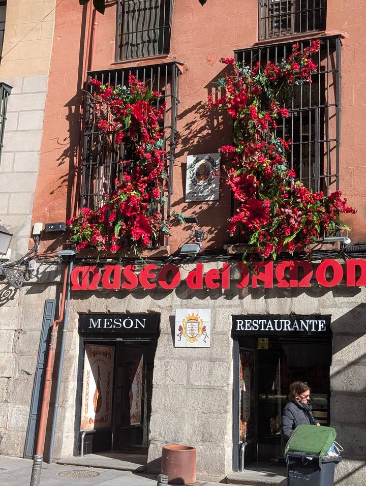 Colorful flower boxes adorn the facade of the iconic Museo del Jamón restaurant.