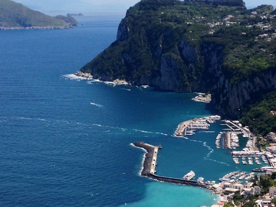 Vue aérienne d'un littoral avec des eaux bleues azur et des falaises.