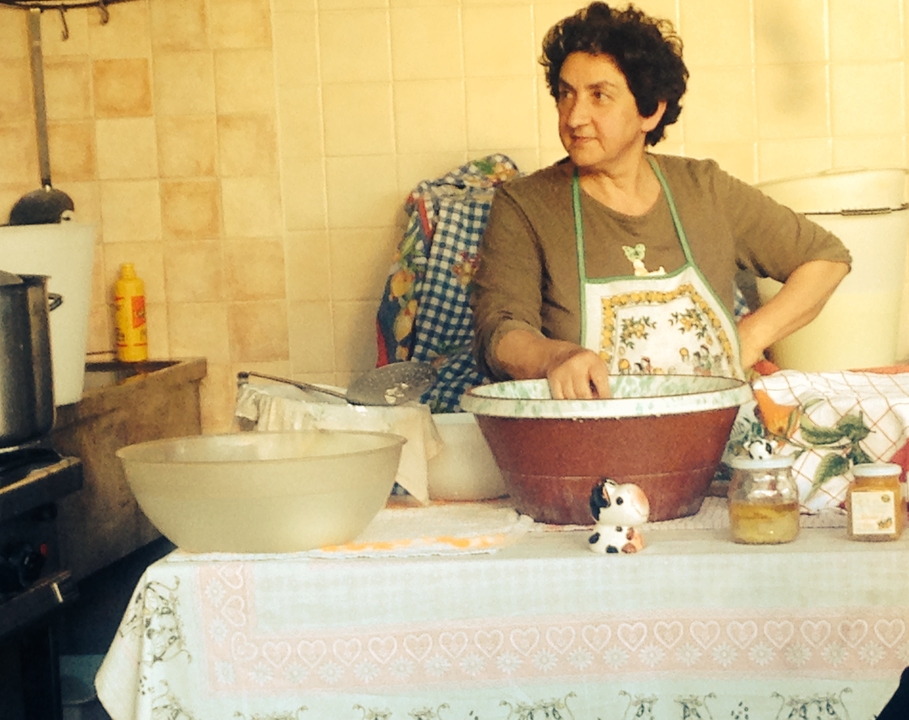 Femme préparant des aliments dans une cuisine.