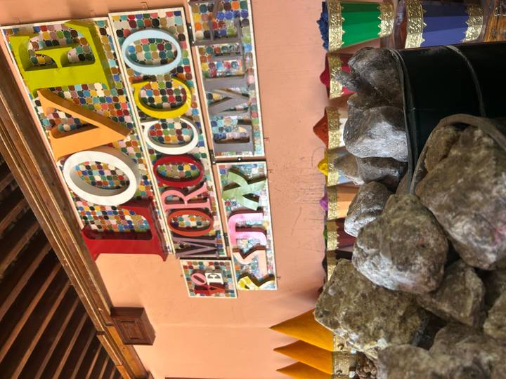 Colorful indoor wall display reading 'LOVE MOROCCO' above buckets of mineral stones