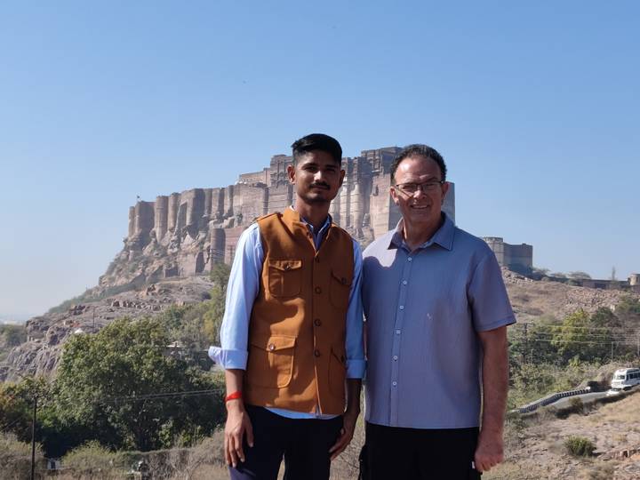 Guide and traveller stand in front of the imposing Mehrangarh Fort in Jodhpur