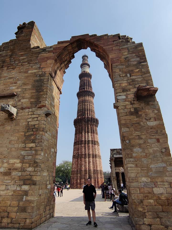 Qutub Minar stone tower framed by ancient sandstone archways in Delhi