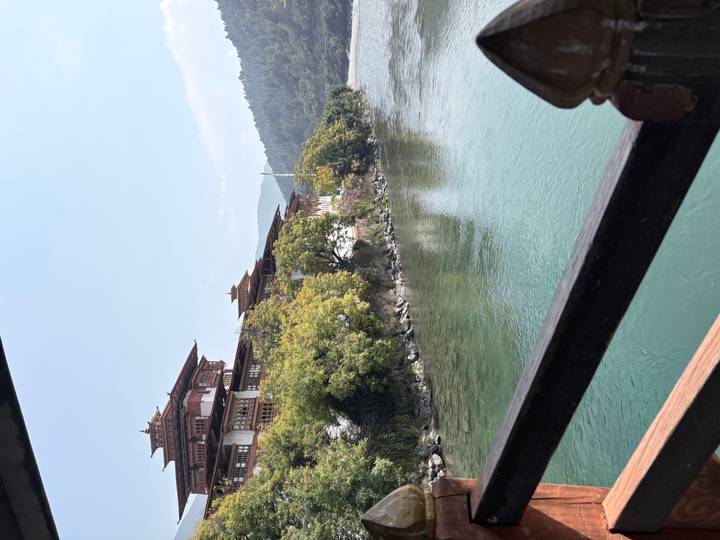 Punakha Dzong stretching along a turquoise river framed by lush green trees.