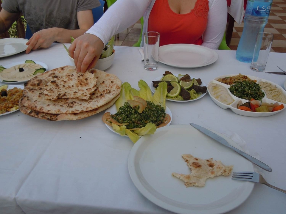 Une table avec divers plats du Moyen-Orient et du pain.