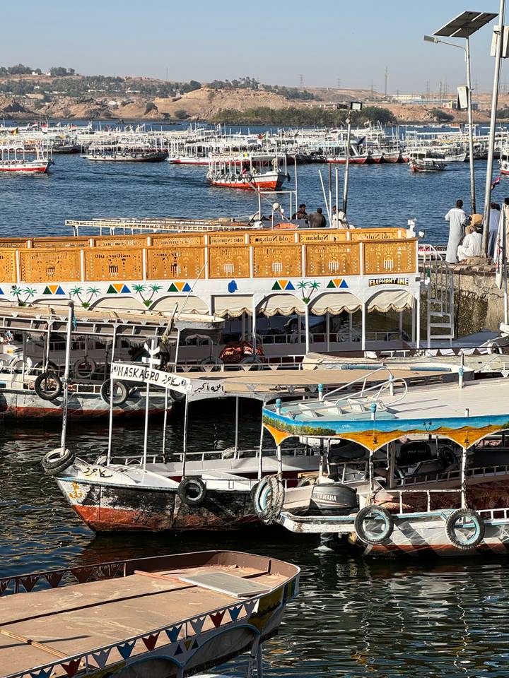 Decorative felucca boats lined up on the Nile with painted wooden cabins.